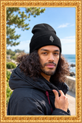 Black cuffed beanie in a fresh outdoor setting inside the gold frame