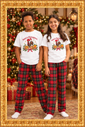 Kids wearing Natal à Portuguesa T-shirts and Christmas pajama bottoms in an ornate gold frame